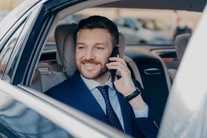 Company manager hearing good news over phone in car photo