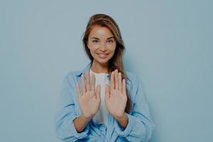 Young beautiful woman in casual clothes standing and holding both hands out photo