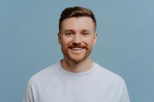 joven, feliz, apuesto, hombre sin afeitar, con ropa informal, sonriendo a la cámara foto