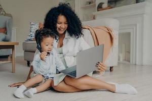 Happy african mom and baby son enjoying video call with family photo