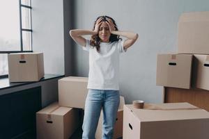 Exhausted woman is tired from packing cardboard boxes with duct tape. Anxiety and stress. photo