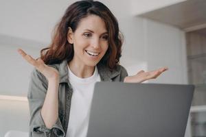 Young woman has video call on laptop and have talk. Online meeting and remote communication. photo