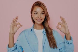 Beautiful woman showing okay gesture with both hands photo