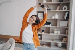 feliz mujer europea está bailando sola en casa. fin de semana, relajación y expresión de emociones. foto