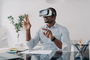 Businessman in vr headset clicks virtual buttons. Modern technology for business and creativity. photo