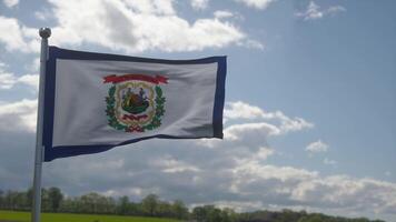 bandera de virginia occidental en un asta de bandera ondeando en el viento, fondo de cielo azul. ilustración 3d foto