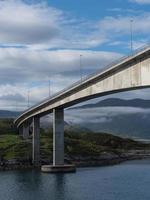 un puente en el norte de noruega, que conecta un paisaje roto por el agua. foto