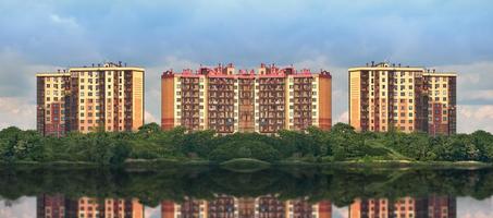 New urban area surrounded by a green Park. Symmetrical new buildings against the sky.. photo