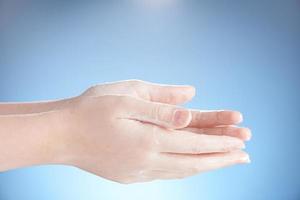 Washing teenager hands isolated on blue background. photo