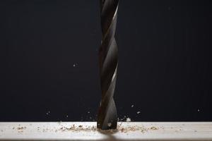 Wood drill bit with shaving on a gray background. Photo with copy space. Background in blur.