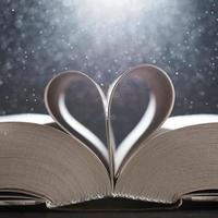 The magical world of reading magic book with pages transforming into heart. The background in blur. photo