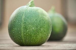 pequeño calabacín verde sobre el fondo de la médula vegetal en un desenfoque. foto