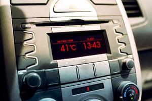 Heat waves in summer. High temperature on car dashboard display. Hot day photo