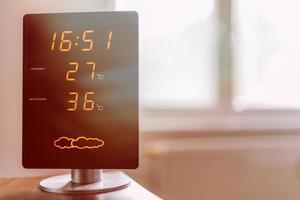 Display of home meteo station showing high interior and exterior temperature during hot summer day photo