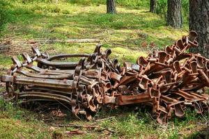 Continuous rusty excavator tracks of bulldozer lying on forest ground on grass photo