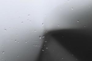Rain drops on a black metallic car surface in a closeup view. photo