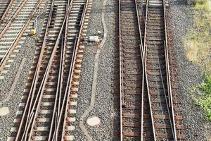 Multiple railroad tracks with junctions at a railway station in a perspective and birds view photo