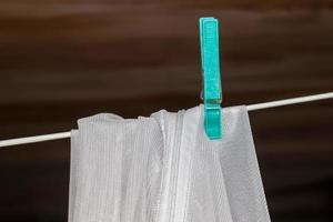 Clothes hung out to dry on a washing line and fastened by the clothes pegs photo