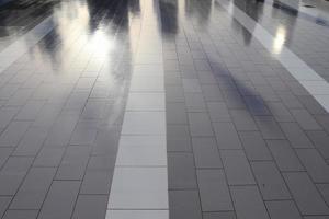 Diffuse reflections of pedestrians walking a marble sidewalk in dubai photo