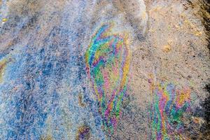 Colorful fuel and oil on an asphalt texture showing enviromental pollution photo