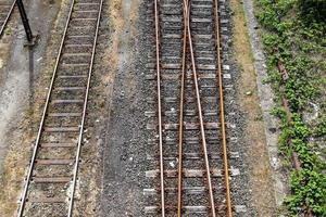 Multiple railroad tracks with junctions at a railway station in a perspective and birds view photo