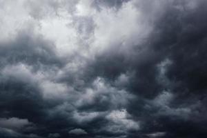 The dark sky with heavy clouds converging and a violent storm before the rain.Bad or moody weather sky. photo