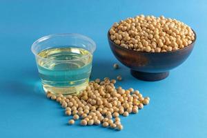 soybean and oil in a bowl on blue background, selective focus.copy space.front view. photo