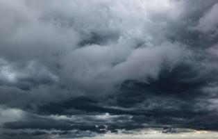 The dark sky with heavy clouds converging and a violent storm before the rain.Bad weather sky. photo