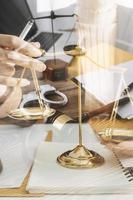 Justice and law concept.Male judge in a courtroom with the gavel, working with, computer and docking keyboard, eyeglasses, on table in morning light photo