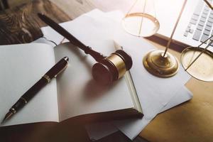 Business and lawyers discussing contract papers with brass scale on desk in office. Law, legal services, advice, justice and law concept picture with film grain effect photo