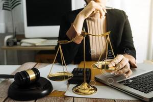 Business and lawyers discussing contract papers with brass scale on desk in office. Law, legal services, advice, justice and law concept picture with film grain effect photo