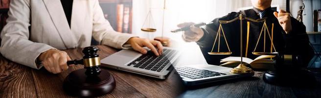 Business and lawyers discussing contract papers with brass scale on desk in office. Law, legal services, advice, justice and law concept picture with film grain effect photo