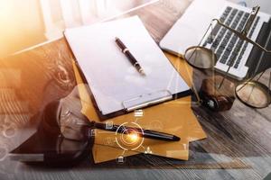 Justice and law concept.Male judge in a courtroom with the gavel, working with, computer and docking keyboard, eyeglasses, on table in morning light photo