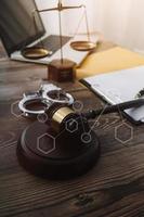 Justice and law concept.Male judge in a courtroom with the gavel, working with, computer and docking keyboard, eyeglasses, on table in morning light photo