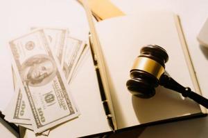 Justice and law concept.Male judge in a courtroom with the gavel, working with, computer and docking keyboard, eyeglasses, on table in morning light photo