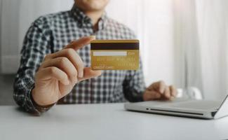 technology, people and online shopping concept - happy smiling man with tablet pc computer and credit card at home photo