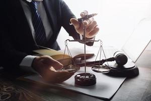 Justice and law concept.Male judge in a courtroom with the gavel, working with, computer and docking keyboard, eyeglasses, on table in morning light photo