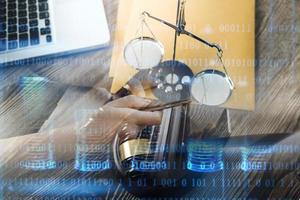 Justice and law concept.Male judge in a courtroom with the gavel, working with, computer and docking keyboard, eyeglasses, on table in morning light photo