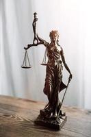 Justice and law concept.Male judge in a courtroom with the gavel, working with, computer and docking keyboard, eyeglasses, on table in morning light photo