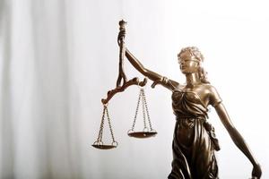 Justice and law concept.Male judge in a courtroom with the gavel, working with, computer and docking keyboard, eyeglasses, on table in morning light photo