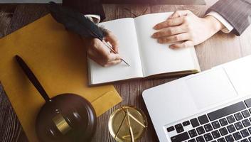 Business and lawyers discussing contract papers with brass scale on desk in office. Law, legal services, advice, justice and law concept picture with film grain effect photo