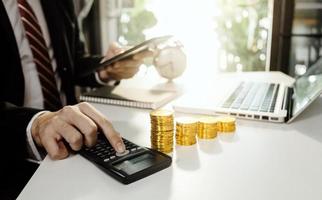 Business accounting concept, Business man using calculator with computer laptop, budget and loan paper in office. photo