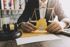 Justice and law concept.Male judge in a courtroom with the gavel, working with, computer and docking keyboard, eyeglasses, on table in morning light photo