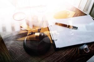 Business and lawyers discussing contract papers with brass scale on desk in office. Law, legal services, advice, justice and law concept picture with film grain effect photo