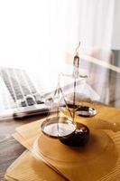 Justice and law concept.Male judge in a courtroom with the gavel, working with, computer and docking keyboard, eyeglasses, on table in morning light photo