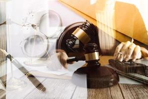 Justice and law concept.Male judge in a courtroom with the gavel, working with, computer and docking keyboard, eyeglasses, on table in morning light photo