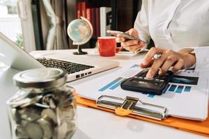 Business accounting concept, Business man using calculator with computer laptop, budget and loan paper in office. photo