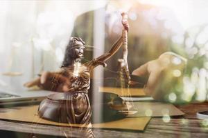 Justice and law concept.Male judge in a courtroom with the gavel, working with, computer and docking keyboard, eyeglasses, on table in morning light photo