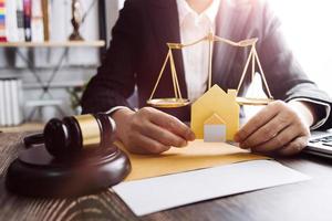 Business and lawyers discussing contract papers with brass scale on desk in office. Law, legal services, advice, justice and law concept picture with film grain effect photo