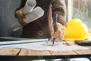 Two colleagues discussing data working and tablet, laptop with on on architectural project at construction site at desk in office photo